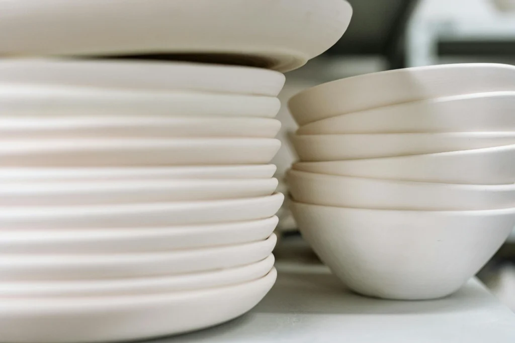 Servies voor op kamers met witte borden en kommen gestapeld